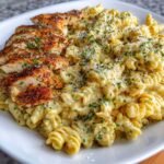 Creamy garlic parmesan chicken pasta in large skillet with golden chicken pieces coated in rich cream sauce