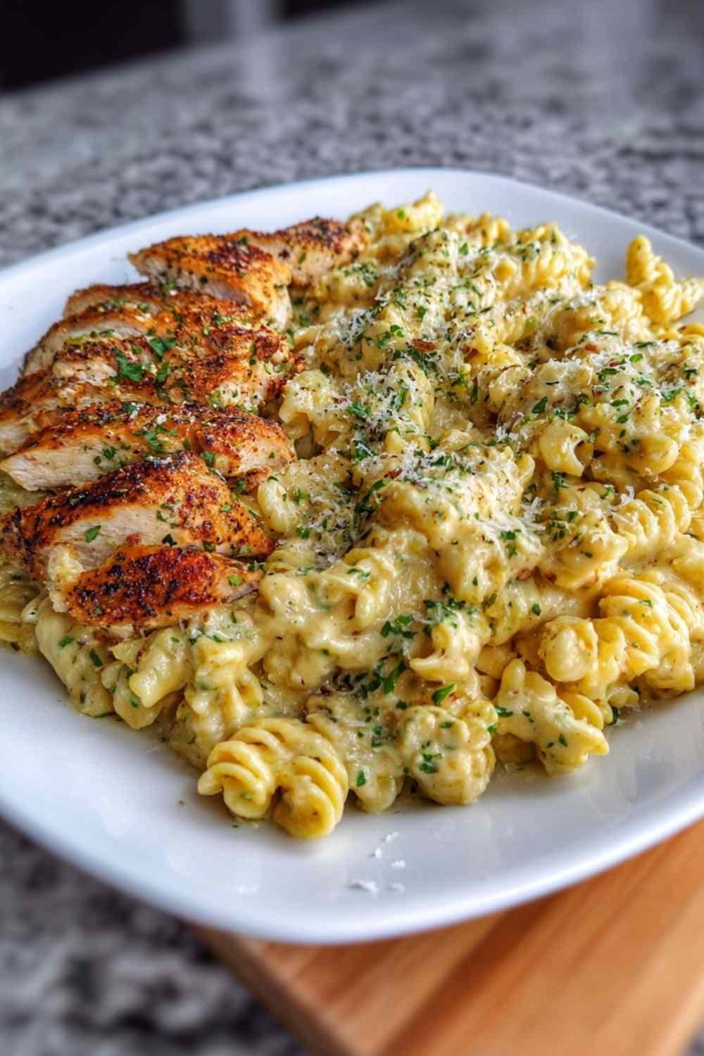 Creamy garlic parmesan chicken pasta in large skillet with golden chicken pieces coated in rich cream sauce